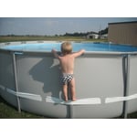Example of child using the compression strap to stand on above-ground pool, illustrating the hazard involved