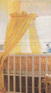 Yellow canopy attached to a stand which is clamped to the frame of a crib.