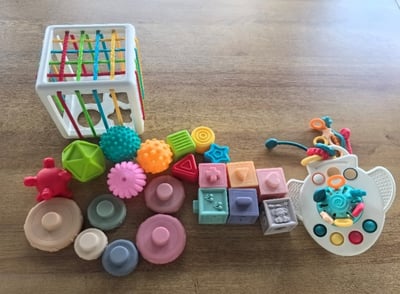 Recalled 5-in-1 Montessori Toy Set (airplane shaped teething toy on far right)