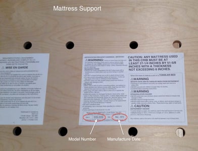 Model number and manufacture date are on the warning label attached to the crib's mattress support.