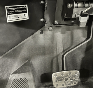 The VIN is visible underneath the driver-side dashboard, left of the foot pedals