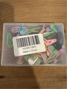 Recalled Dlesot Snap Hair Clips in plastic container with label