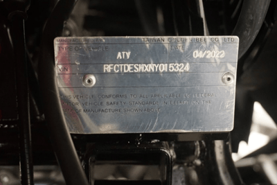 The adult ATV's model number appears on a plate located next to the vehicle's front right tire